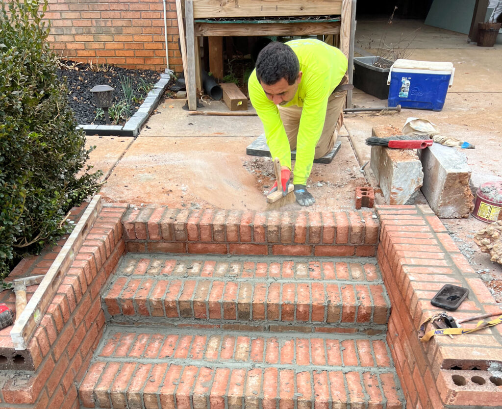 Masonry contractor repairing damaged residential brick steps
